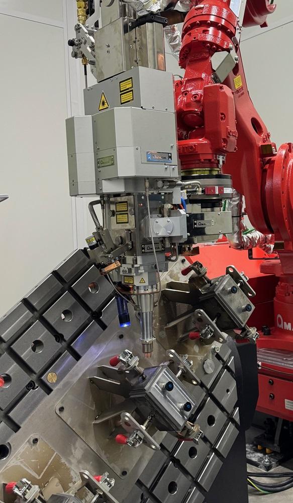 A robot performs laser welding.