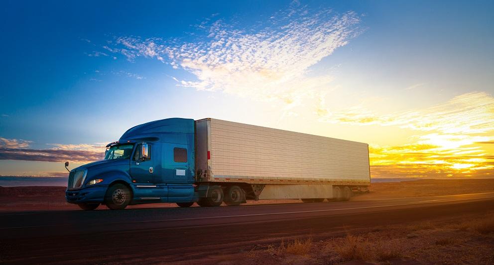 A semitruck and its trailer drive down the road.