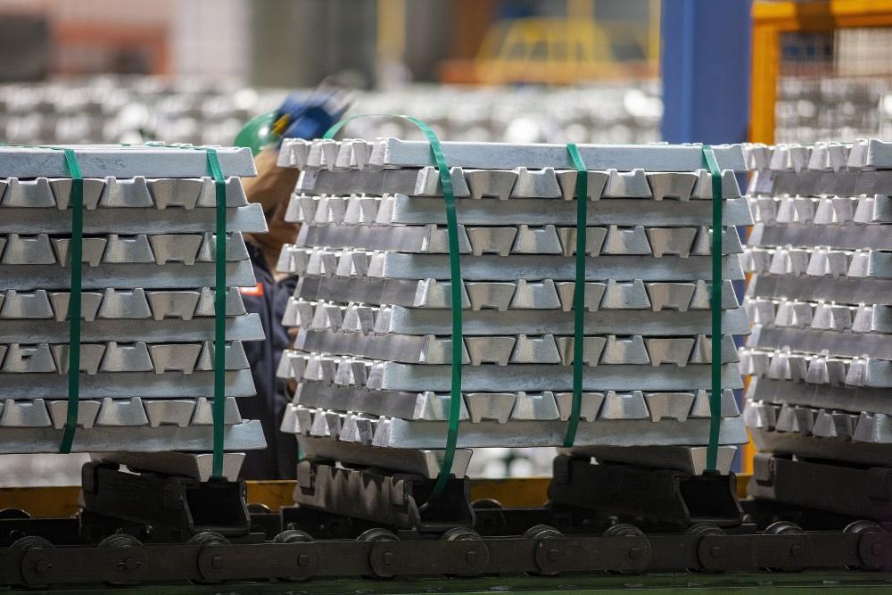 Freshly molded aluminum ingots stacked on pallets, ready for distribution.