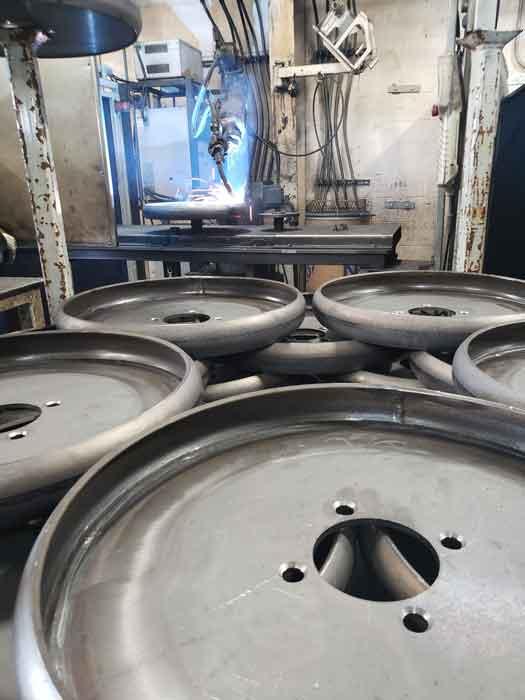 Robotic welding cell welds wheels for agriculture equuipment