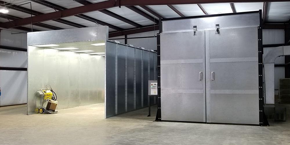 A powder coating booth is positioned next to a curing oven.