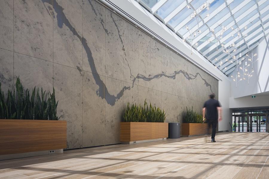 An office lobby wall made of anodized aluminum panels that mimic the Ottawa River is shown.