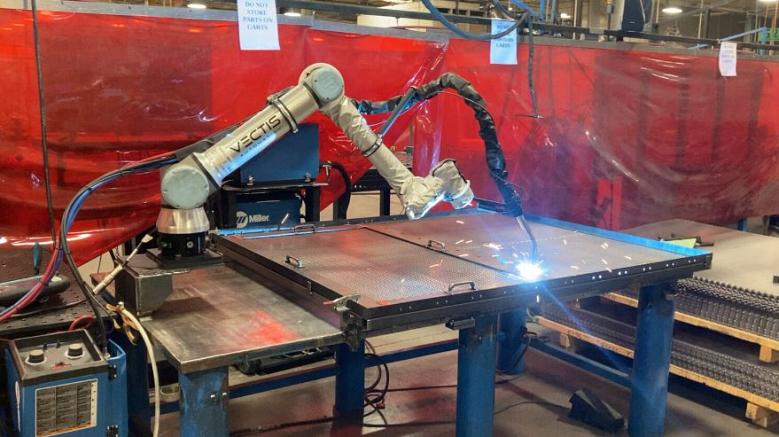 A collaborative robot welds a sheet metal part.