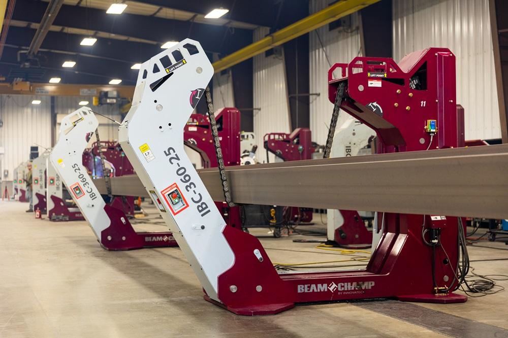 A steel beam is held in place by a machine.