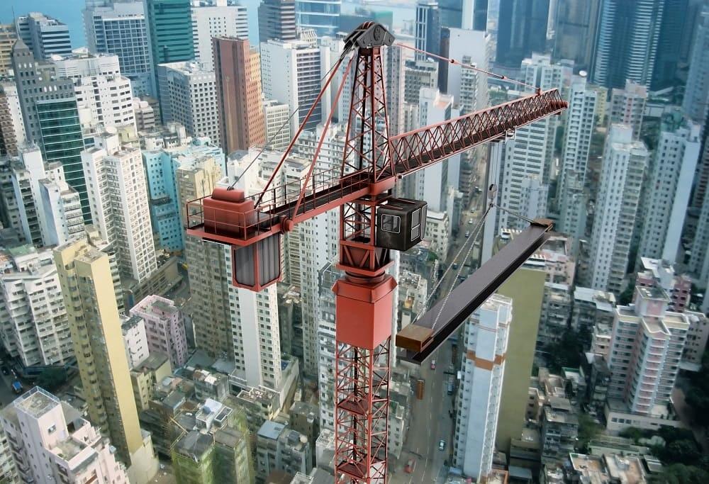Crane carrying a steel beam on a construction site.