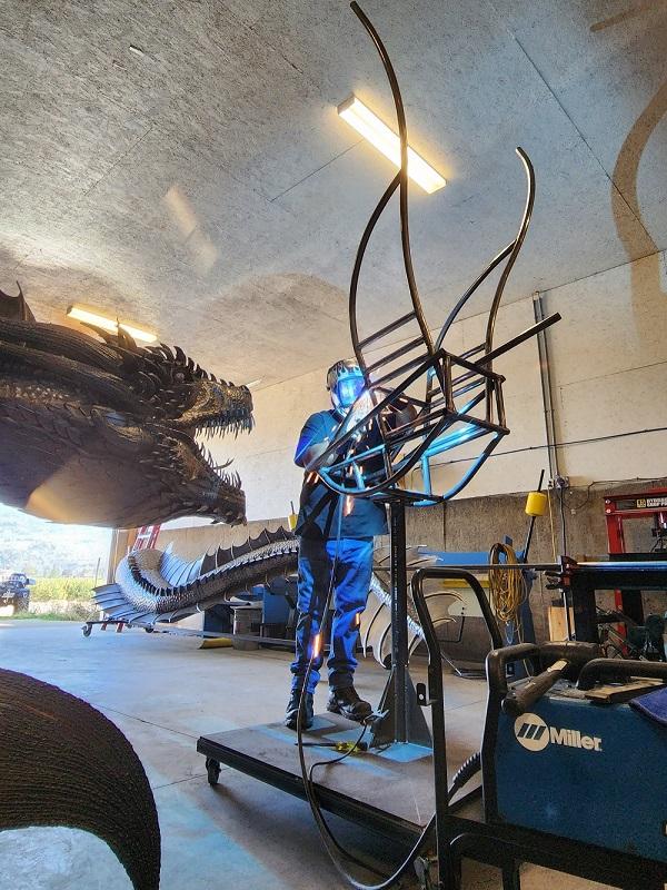 Metalni umjetnički kipar i umjetnik s metalnom skulpturom zmaja