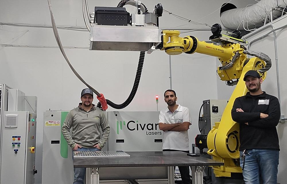 Three people pose with a robot.