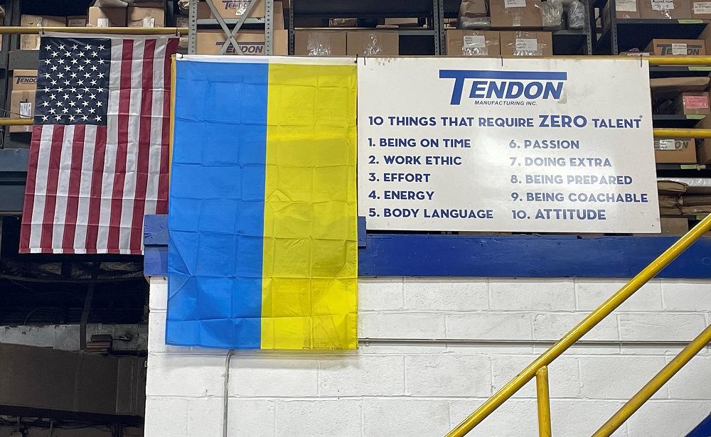 A United States flag and Ukraine flag displayed in a manufacturing shop