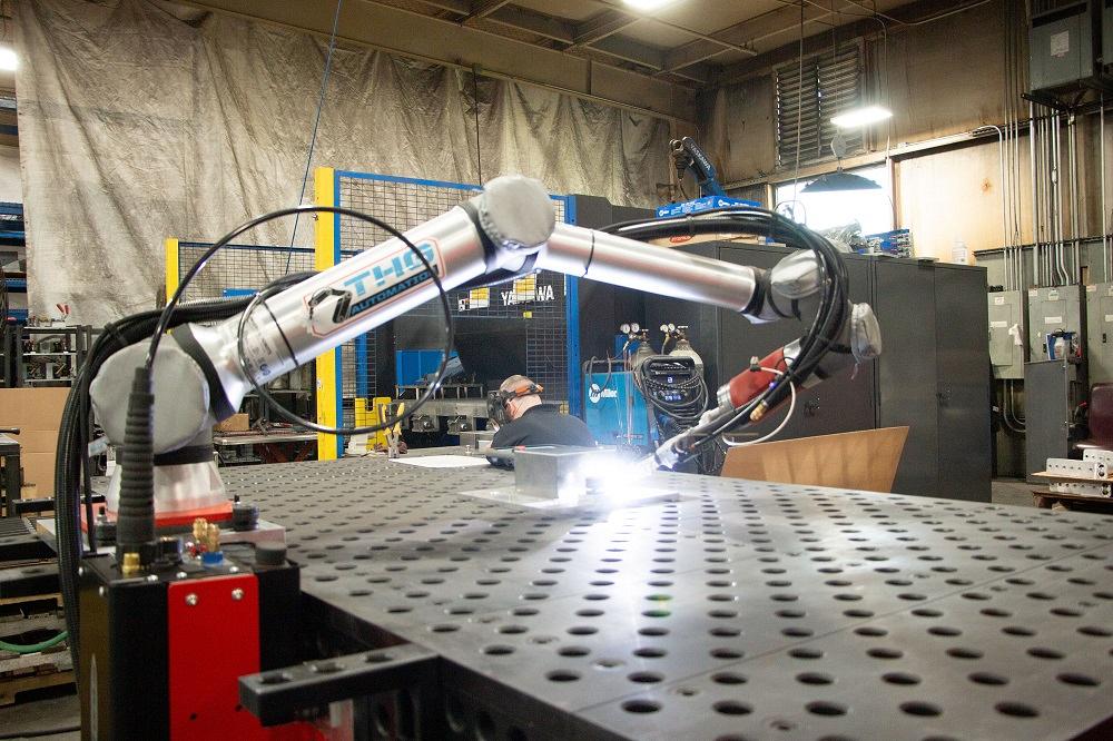 A robot welds a piece of metal.