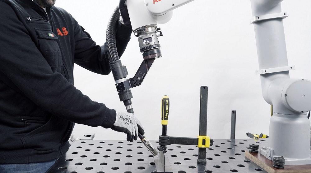 A worker teaches a welding sequence to a cobot. 
