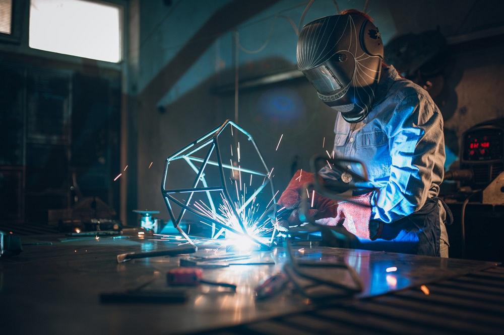 A person welds a sculpture.