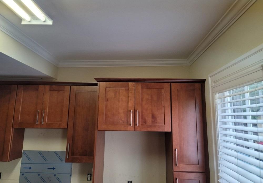 Kitchen cupboards look uneven with the ceiling.