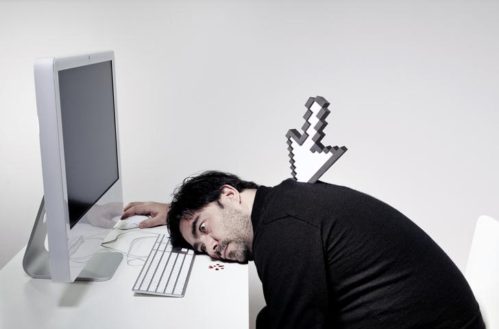 A computer arrow sticks in the back of a man slumped in front of a computer.