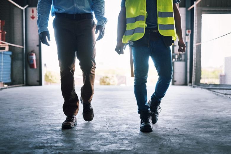 Two builders walking through a construction site