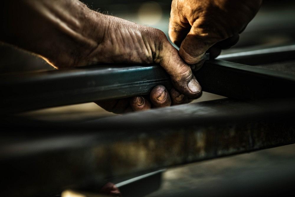 Close up of unrecognizable worker working with iron.