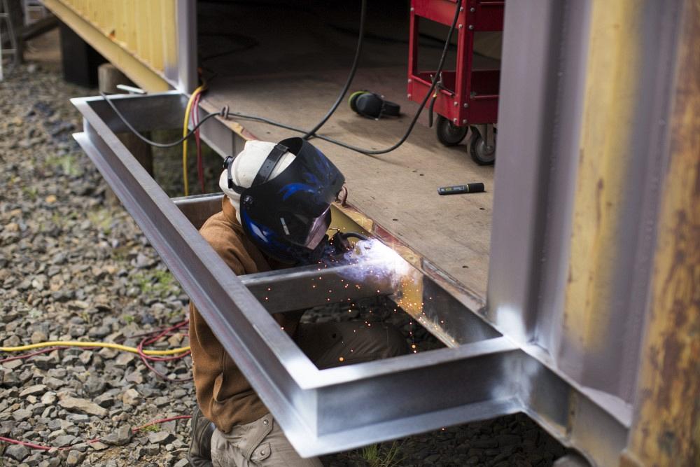 Welder working on steel shipping container