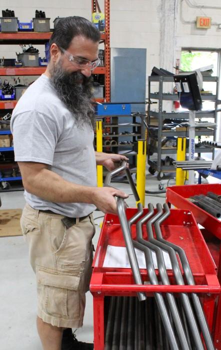 Metal fabricator examines metal tube parts manufacturer