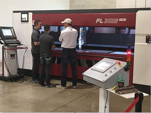 Fabricators take a look at the interior of a fiber laser cutting machine.