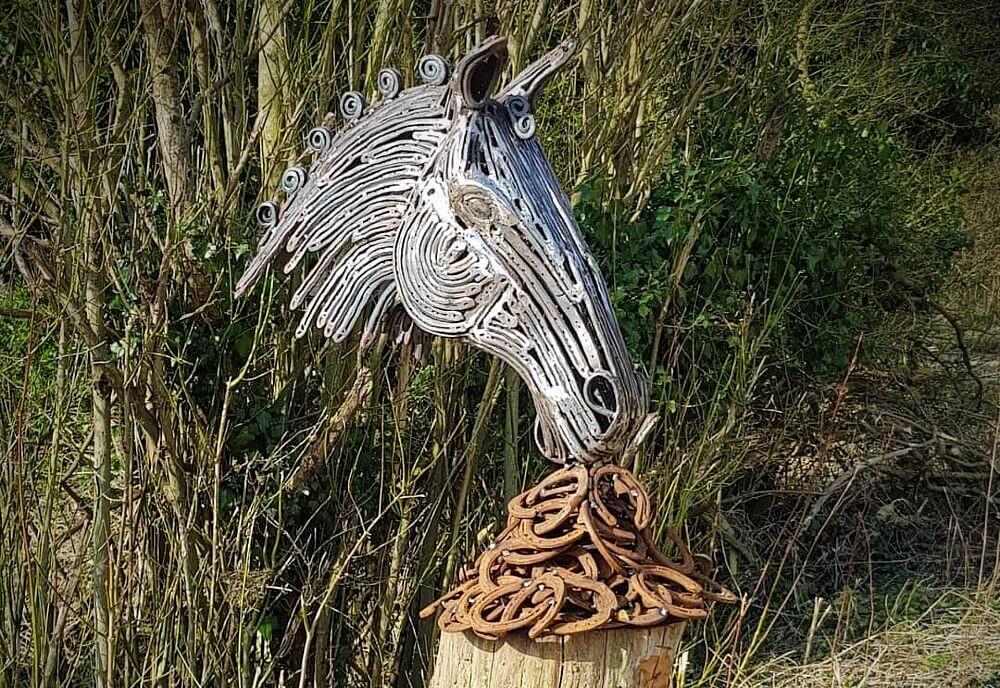 Metal sculpture of a horse head and horseshoes 