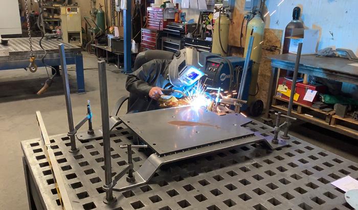 A welder at Precision Cut Industries