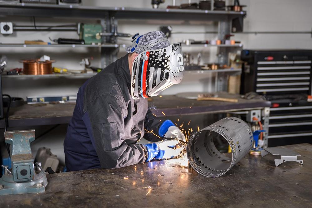 Welder wearing Miller Electric equipment and working in a metal fabrication shop