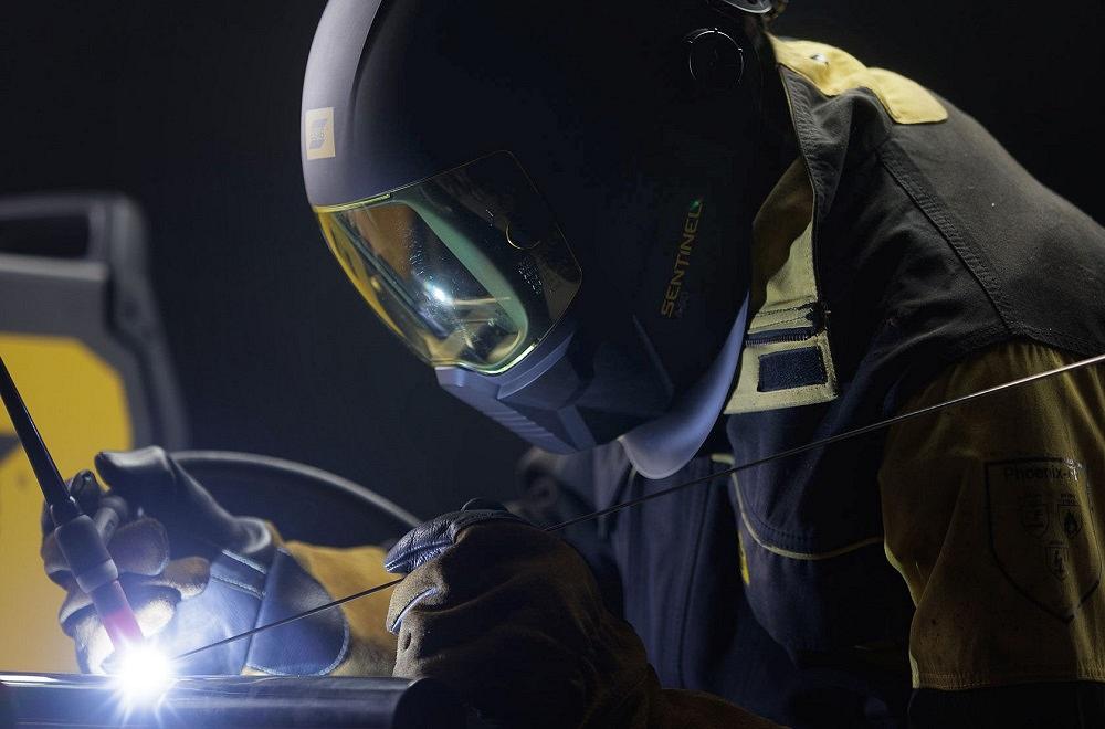 Welder wearing ESAB equipment and working in a metal fabrication shop
