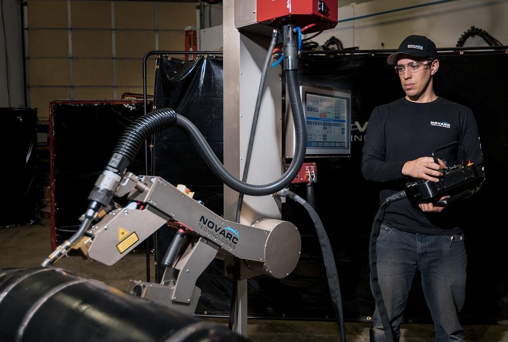 A person operates a welding cobot.