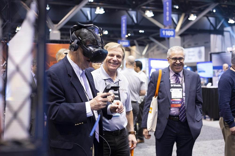 A man wears a VR headset at a trade show.
