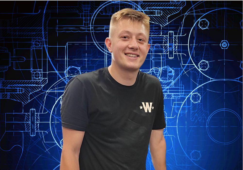 A man stands in front of blueprint
