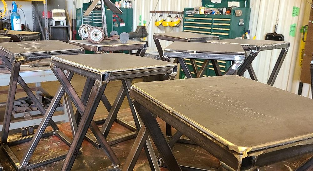 Welded tables crafted by camp participants are shown.
