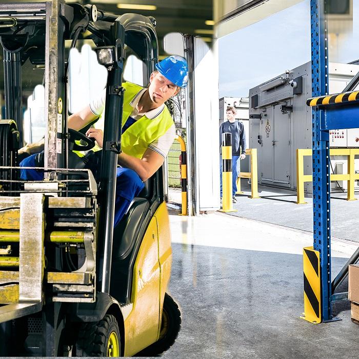 A forklift drives past a safety barrier