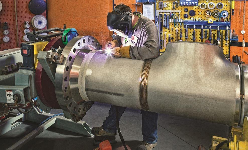 welder working on metal pipe