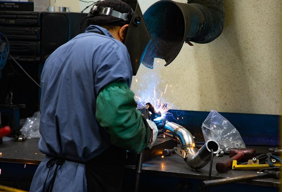 A man welds a tubular part.
