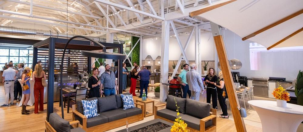 People stand in showroom of patio furniture and grills.