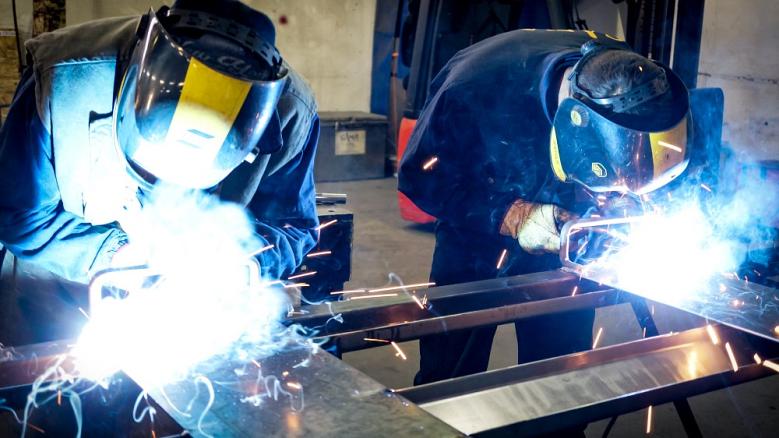 two welders working in a metal fabrication shop