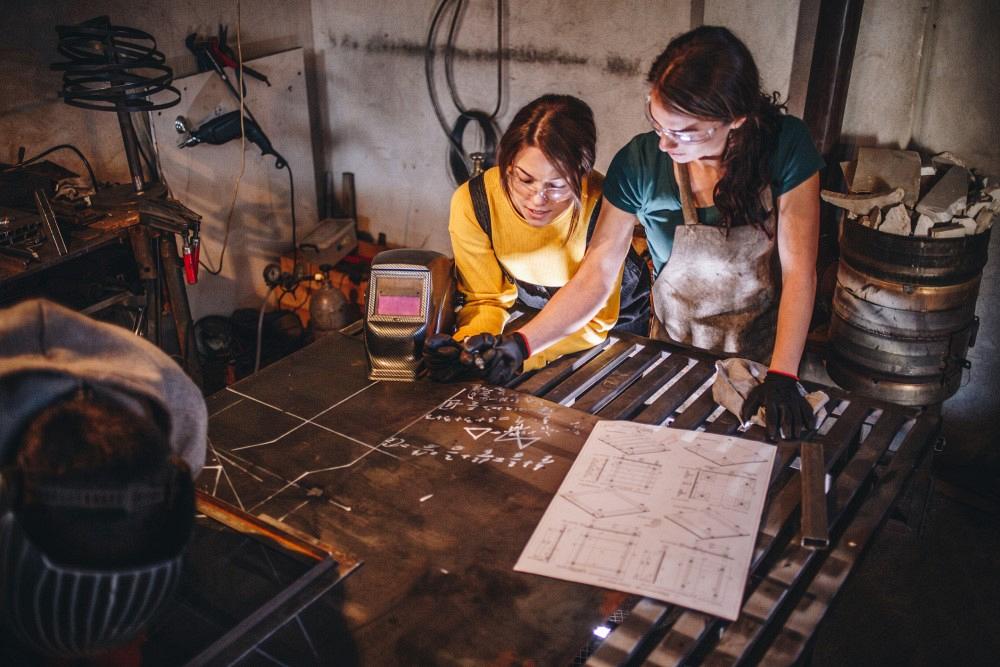 Welders looking over blueprints in a metal fabrication shop