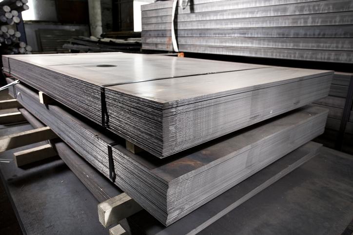 Stainless steel metal sheets are organized in stacks.