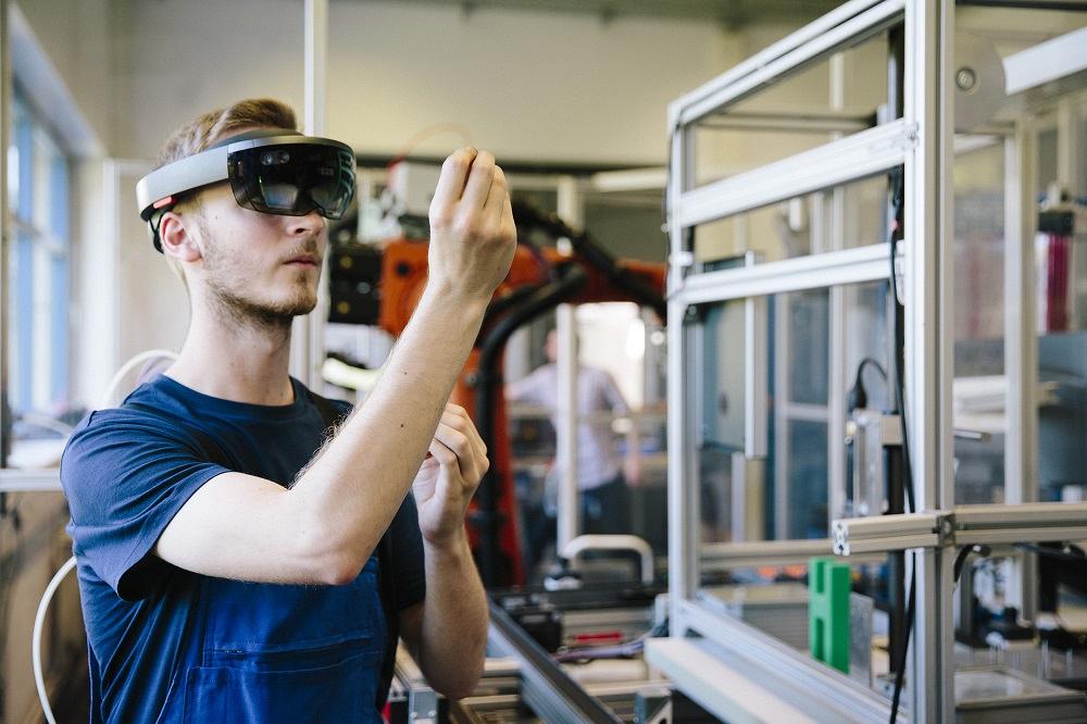An engineer follows assembly instructions using an augmented reality headset.