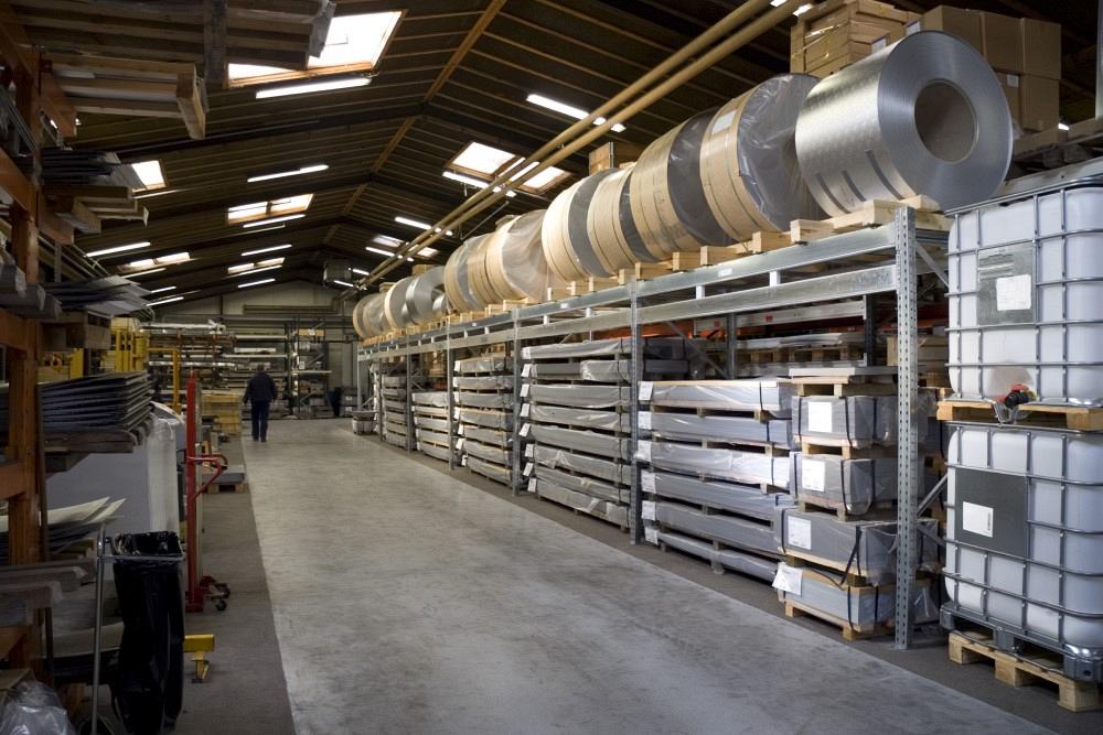 Rolls of sheet steel stored on racking on factory floor