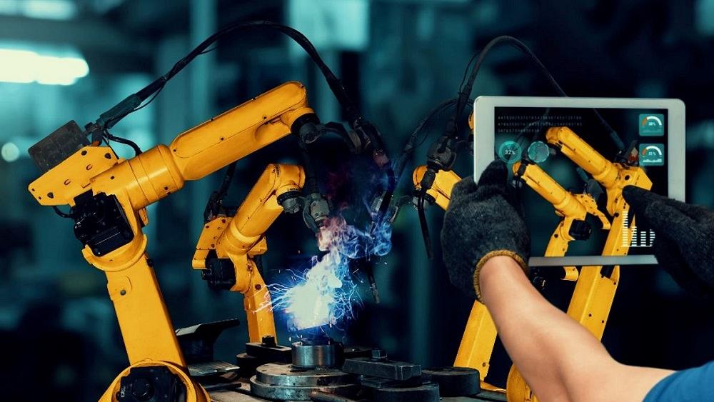 Hands operating a welding cobot.