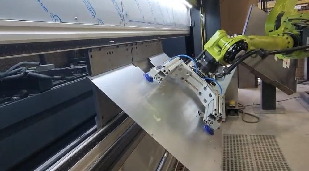 A robotic arm positions a metal sheet on a press brake.