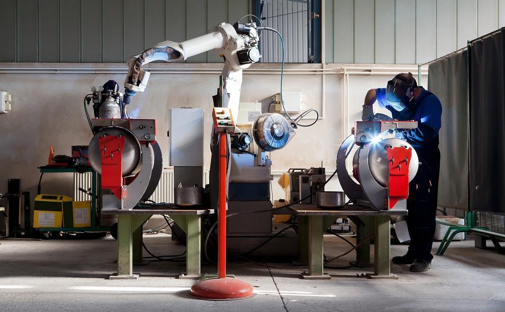 Automated welding robot and skilled worker in fabrication facility