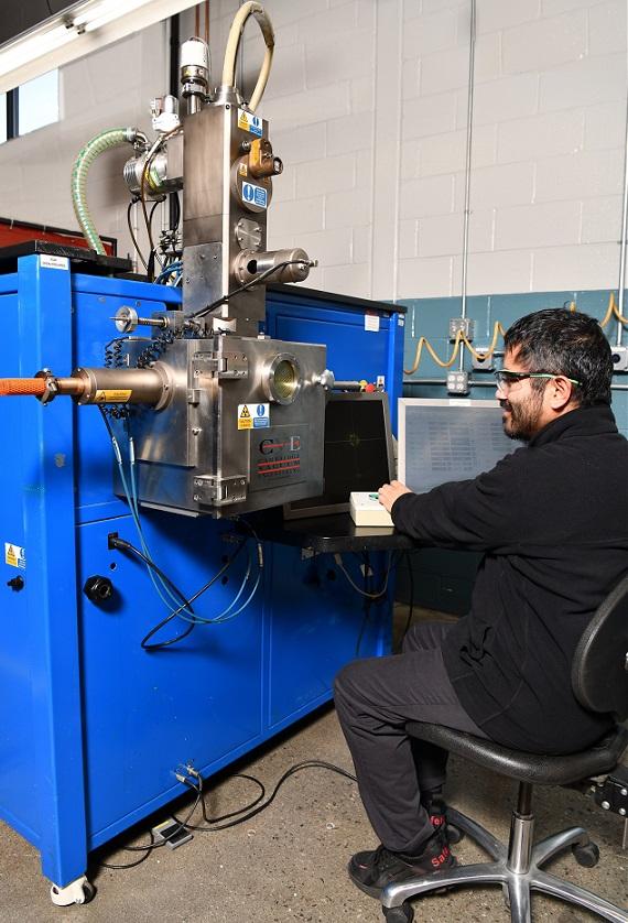 A man works with an electron beam welding machine.