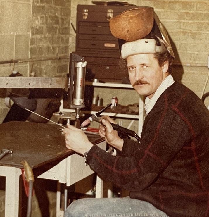 A man prepares to TIG weldat a workbench.