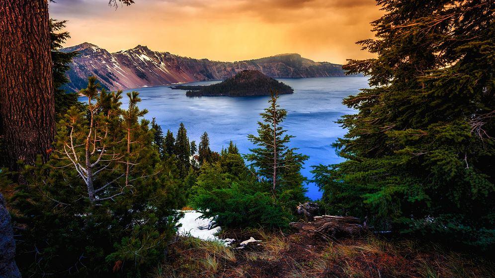 Crater Lake is surrounded by mountains and trees.