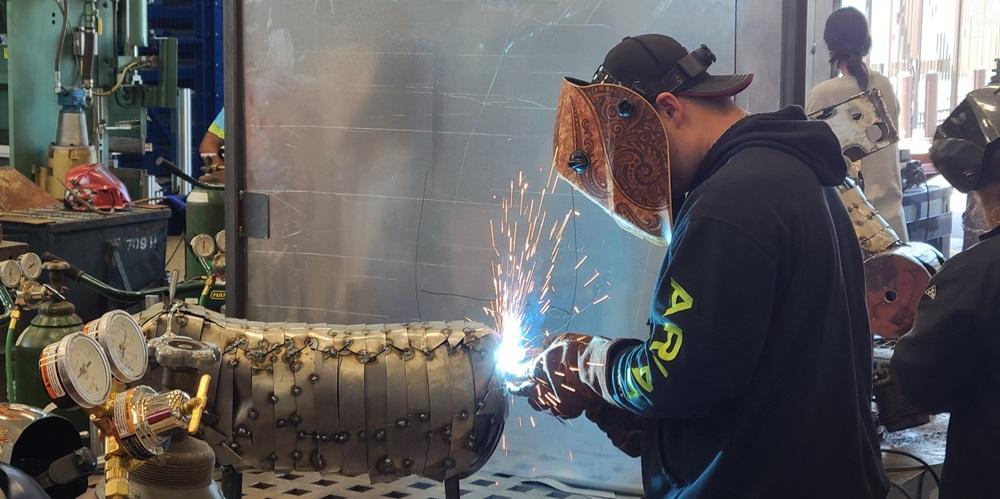 A contestant welds.