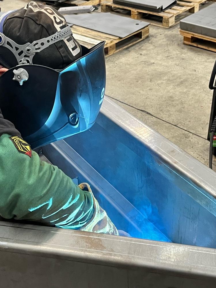 A worker welds a piece of metal.
