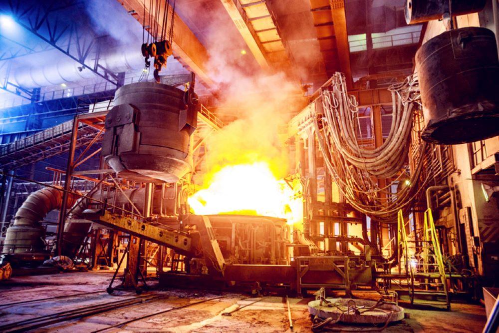 Scrap metal is poured into an electric arc furnace at a steel factory.