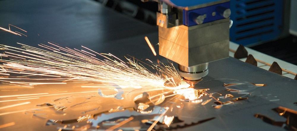 Sparks fly as a laser cuts sheet metal.