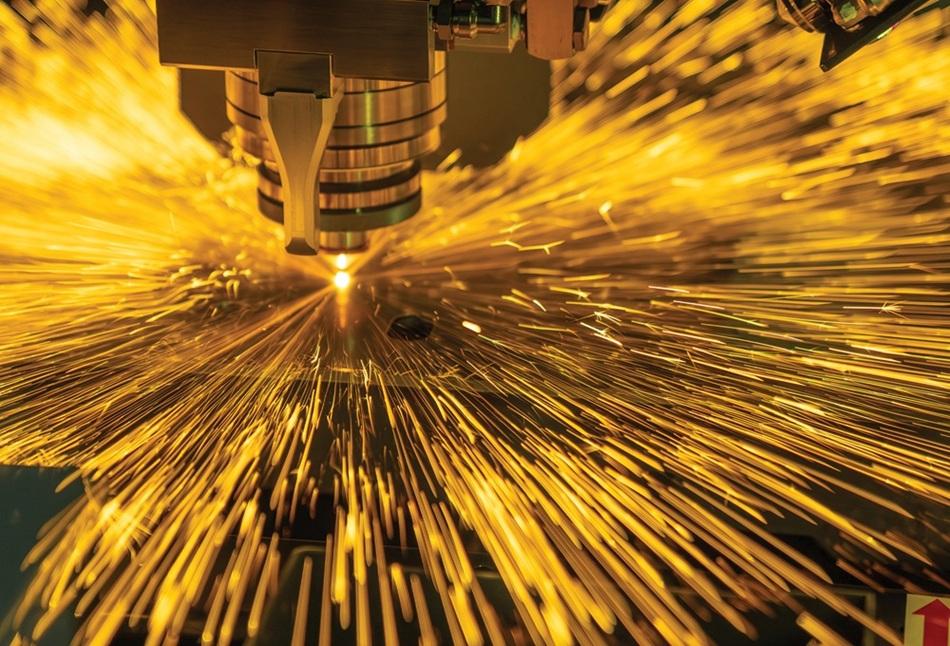 Yellow sparks fly as a laser cuts metal.